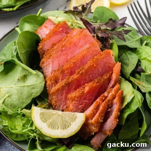 crispy seared ahi tuna salad with mixed greens and lemon wedge
