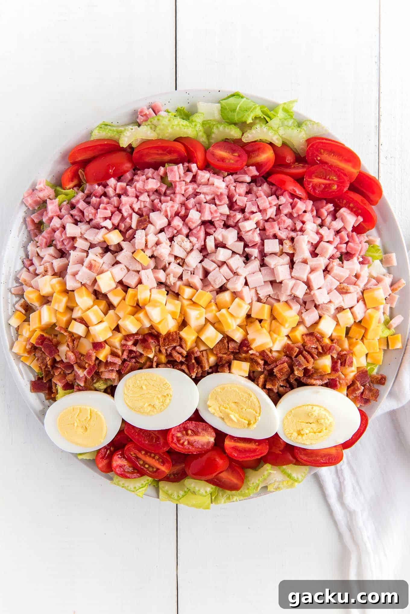 A Chef salad on a white platter on the table.
