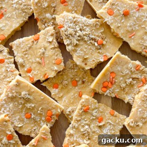 Kid-Friendly Halloween Snack Ideas Kids Will Love 17 Pumpkin yogurt bark on a wooden board.