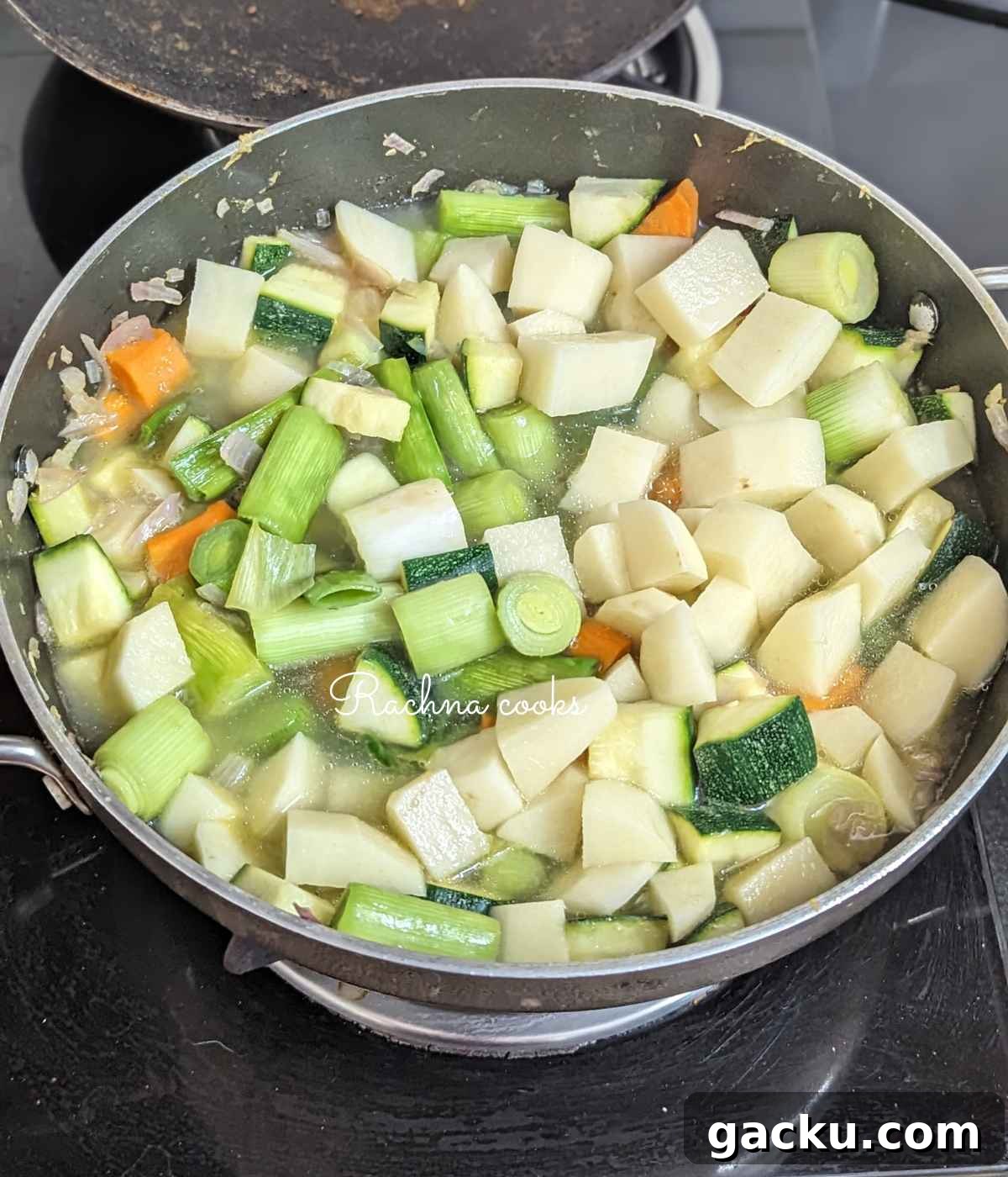 Creamy Leek, Cauliflower & Potato Soup Recipe for Cozy Meals 6 Potatoes, leeks, zucchini, carrot, cauliflower, onion and garlic with stock in a pan.