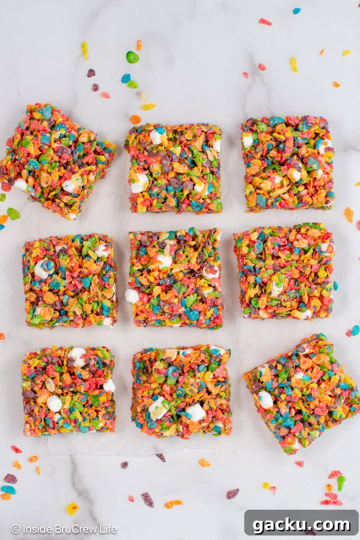 Fruity Pebbles Rice Krispie Treats Recipe 5 Fruity pebbles treats on a white board.