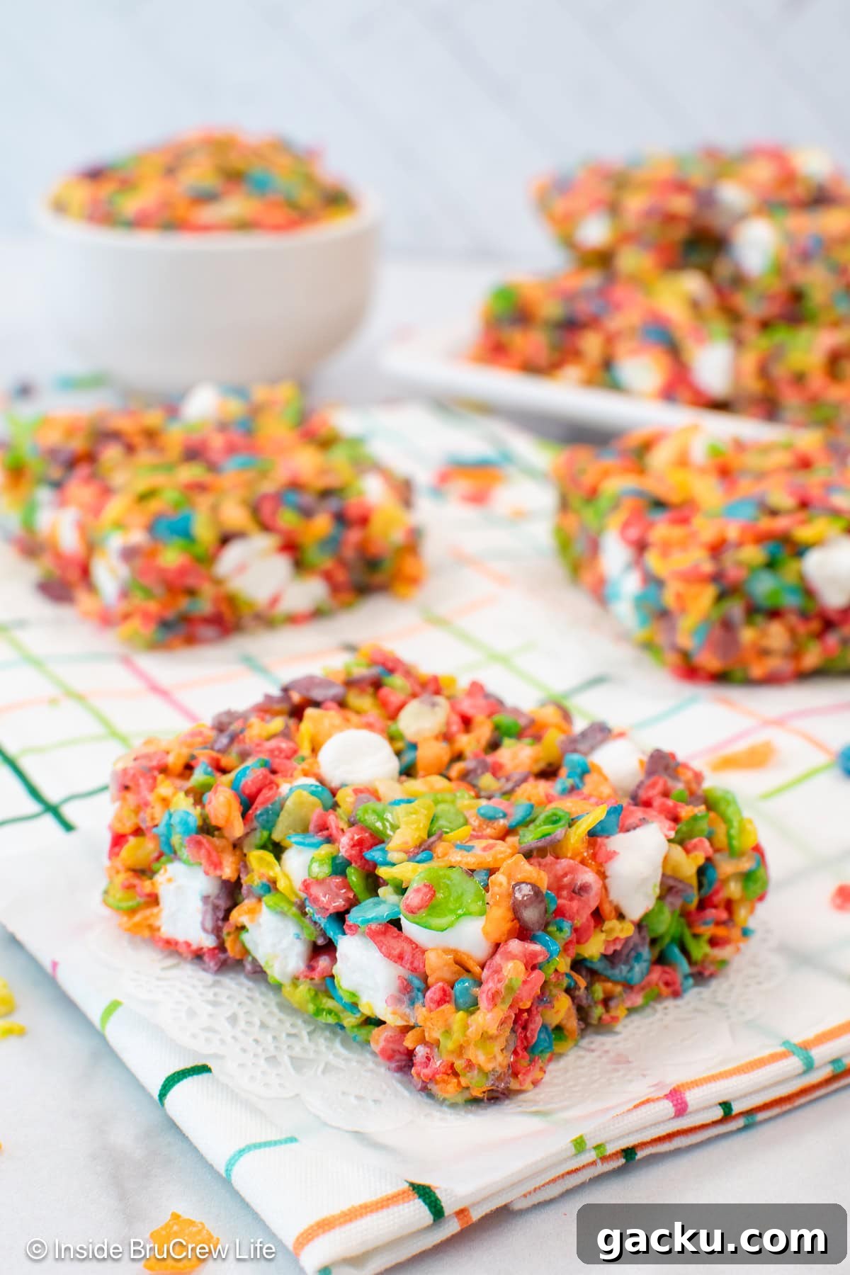 Fruity Pebbles Rice Krispie Treats Recipe 6 Fruity rice crispy treats on a white towel.