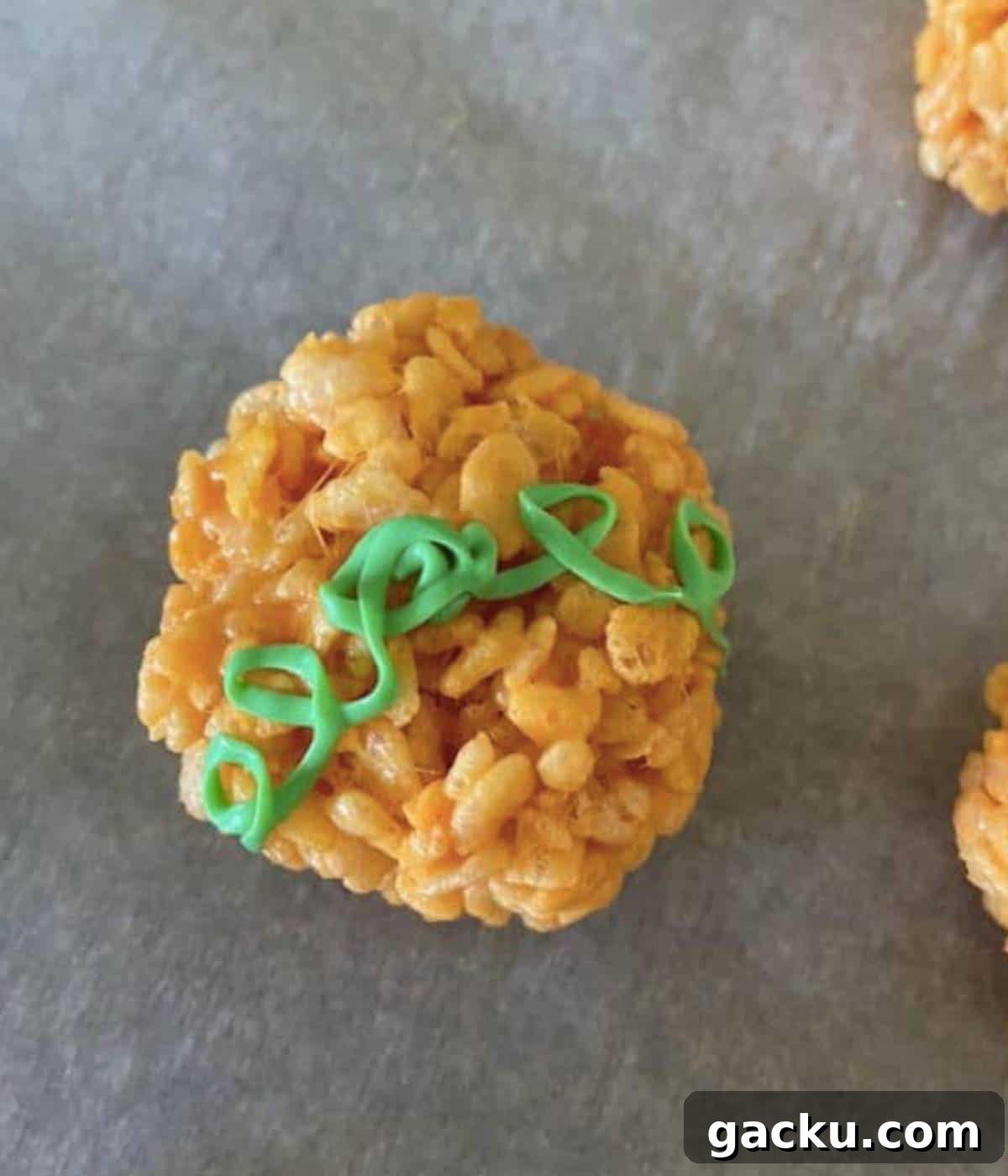 Pumpkin Rice Krispie Treats Recipe for Fall Desserts 9 Green icing over rice krispie pumpkin in vine shape.