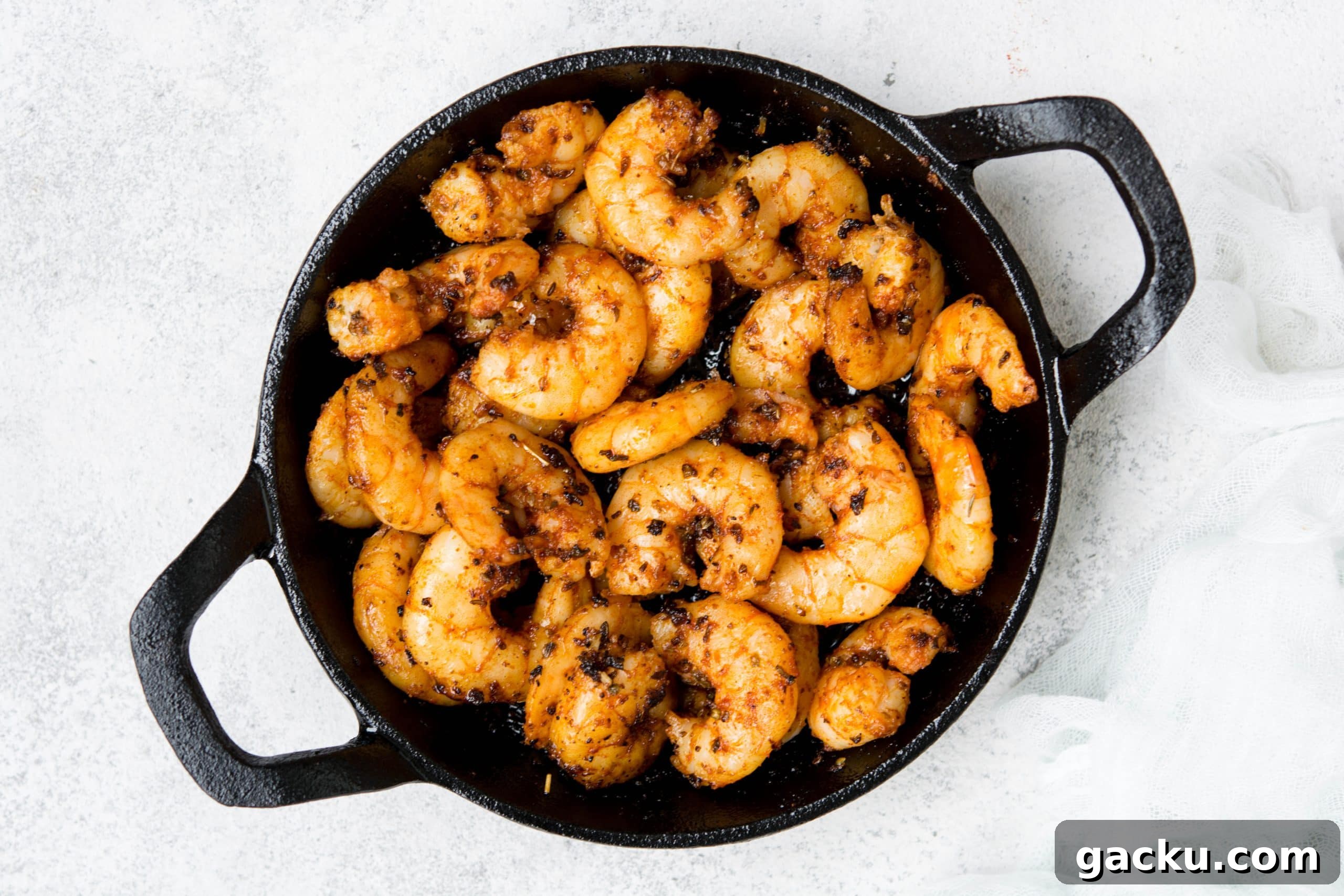 Spicy Blackened Shrimp Tacos with Cilantro Lime Slaw 3 blackened keto shrimps in a cast-iron skillet