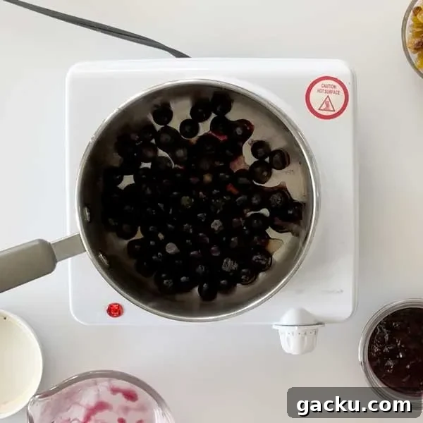 Adding frozen blueberries to a sauce pan.