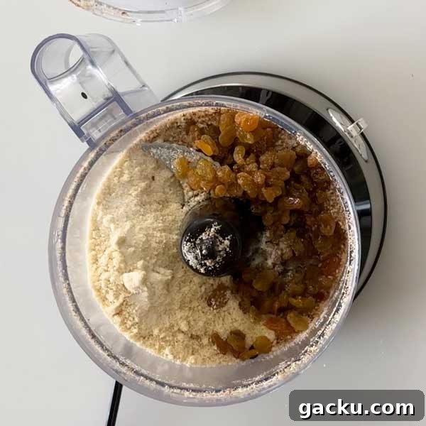Adding the remaining cheesecake crust ingredients to the food processor.