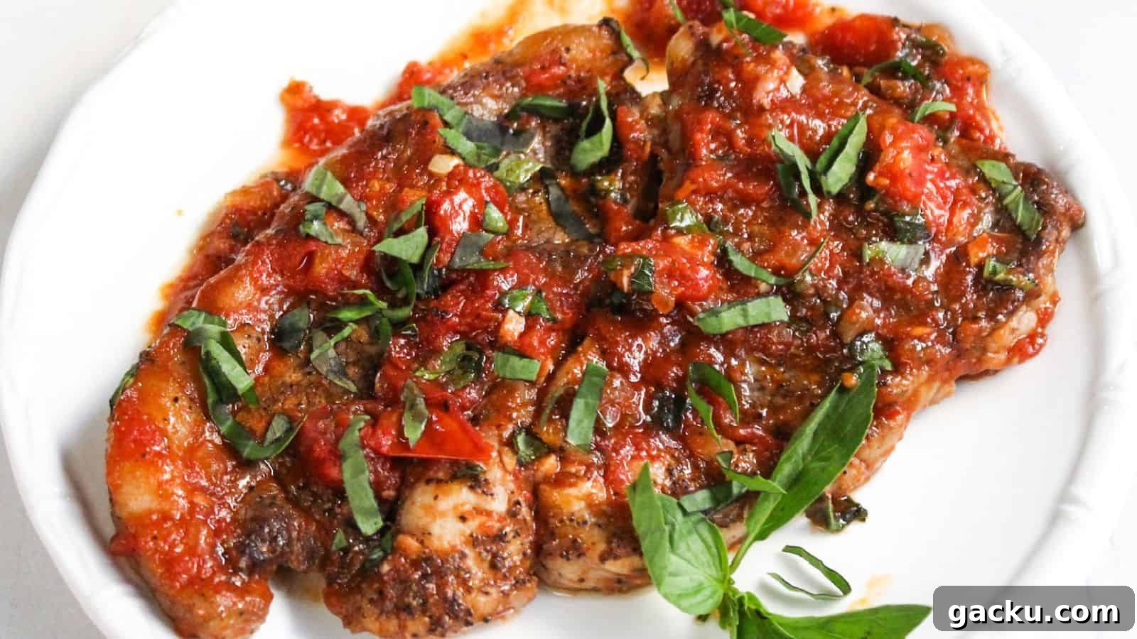 30 One-Pan Skillet Meals for Quick Cleanup and Big Flavor 11 Fried steak topped with a chunky tomato and basil sauce, served on a white plate.