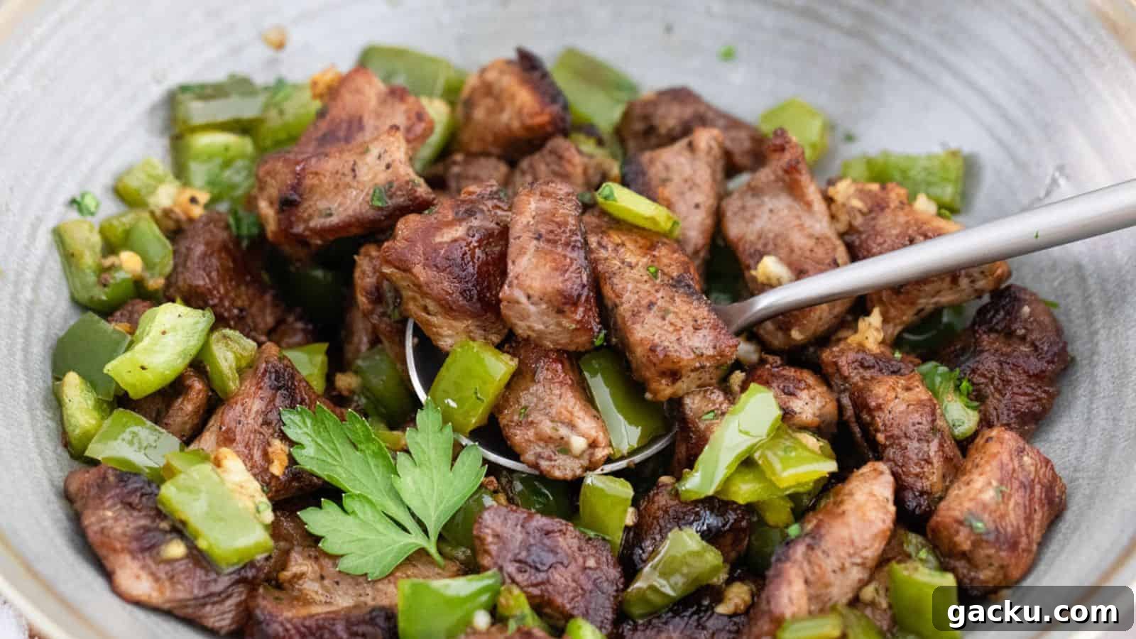 30 One-Pan Skillet Meals for Quick Cleanup and Big Flavor 16 A bowl of meat and green peppers with a spoon.