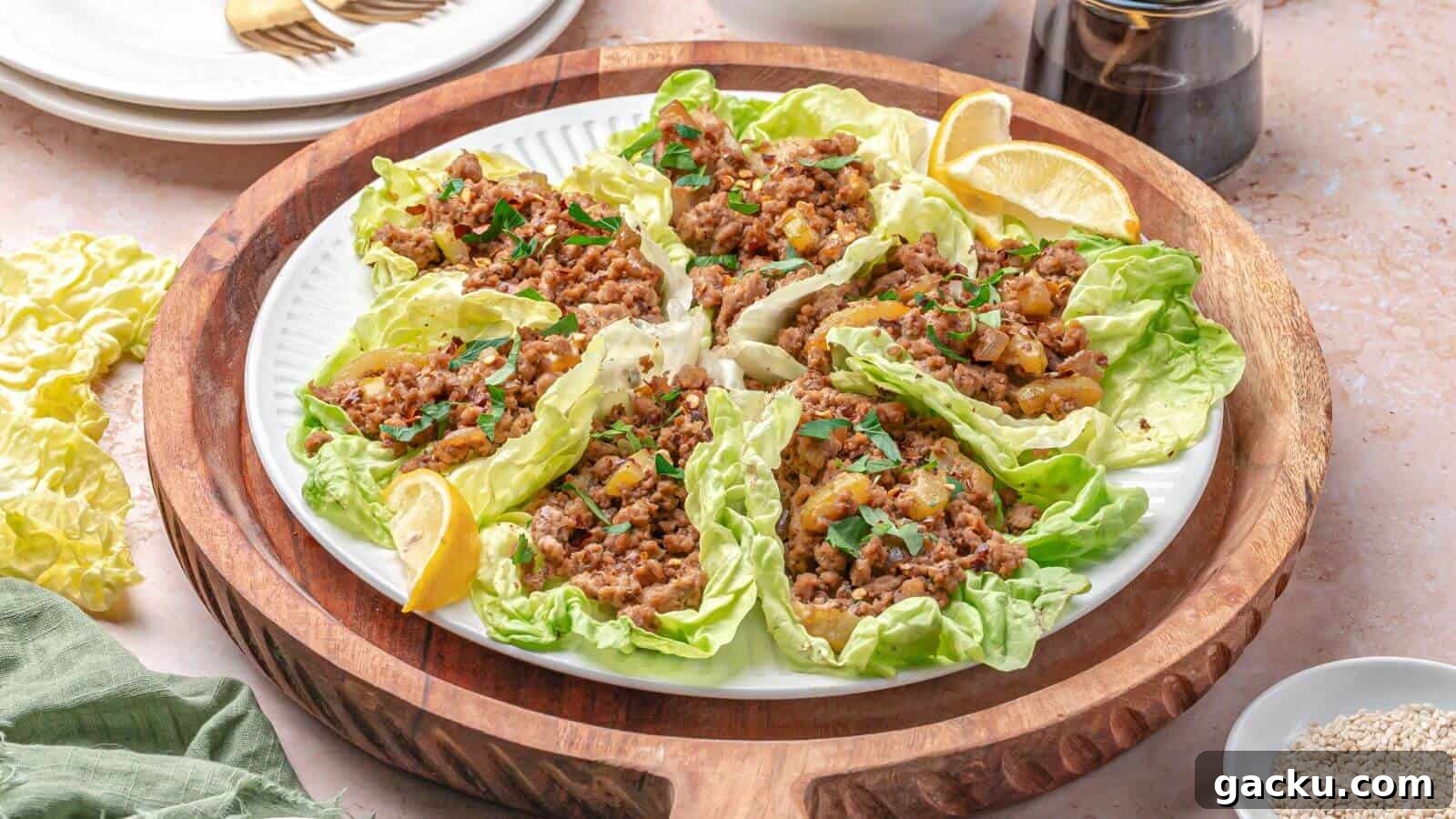 30 One-Pan Skillet Meals for Quick Cleanup and Big Flavor 24 A plate of lettuce wraps filled with seasoned minced meat and garnished with herbs, served with lemon wedges on a wooden tray.