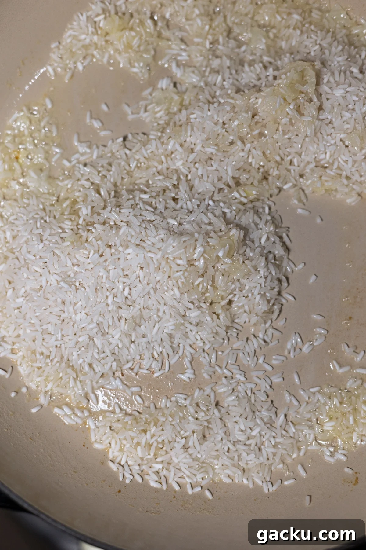 Simple Rice Pilaf Recipe: Fluffy, Flavorful Rice Pilaf in 30 Minutes 6 Pearling rice in a skillet with melted butter and sauteed onion.