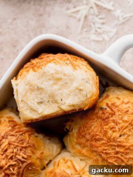 Fluffy cheddar cheese rolls with one on its side.