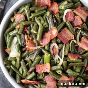 green beans with bacon and onions in a bowl with spoon