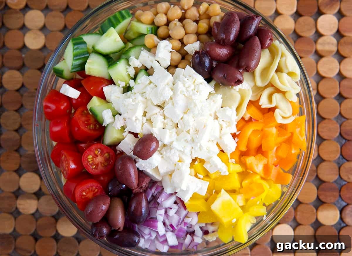 Greek Tortellini Salad with Feta, Olives & Lemon Dressing 5 Ingredients for greek tortellini salad in a mixing bowl.