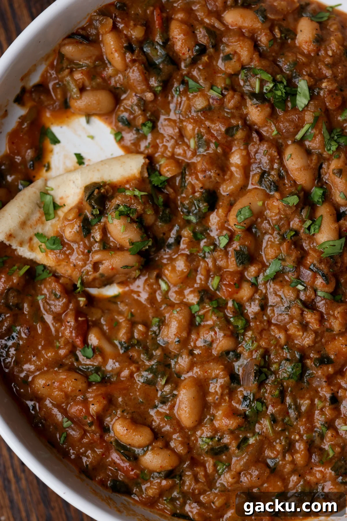 flatbread piece in a bowl of lentil bean stew