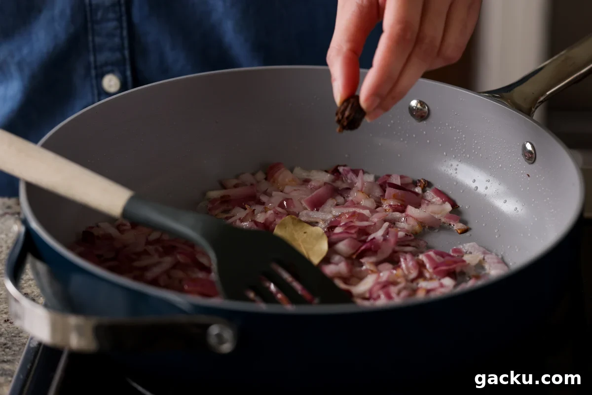 adding whole spices to the onions