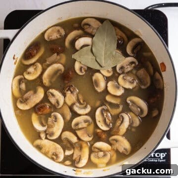 Creamy Chicken Tortellini Soup Recipe for Cozy Weeknights 9 Broth added to the pot and simmering with bay leaves.