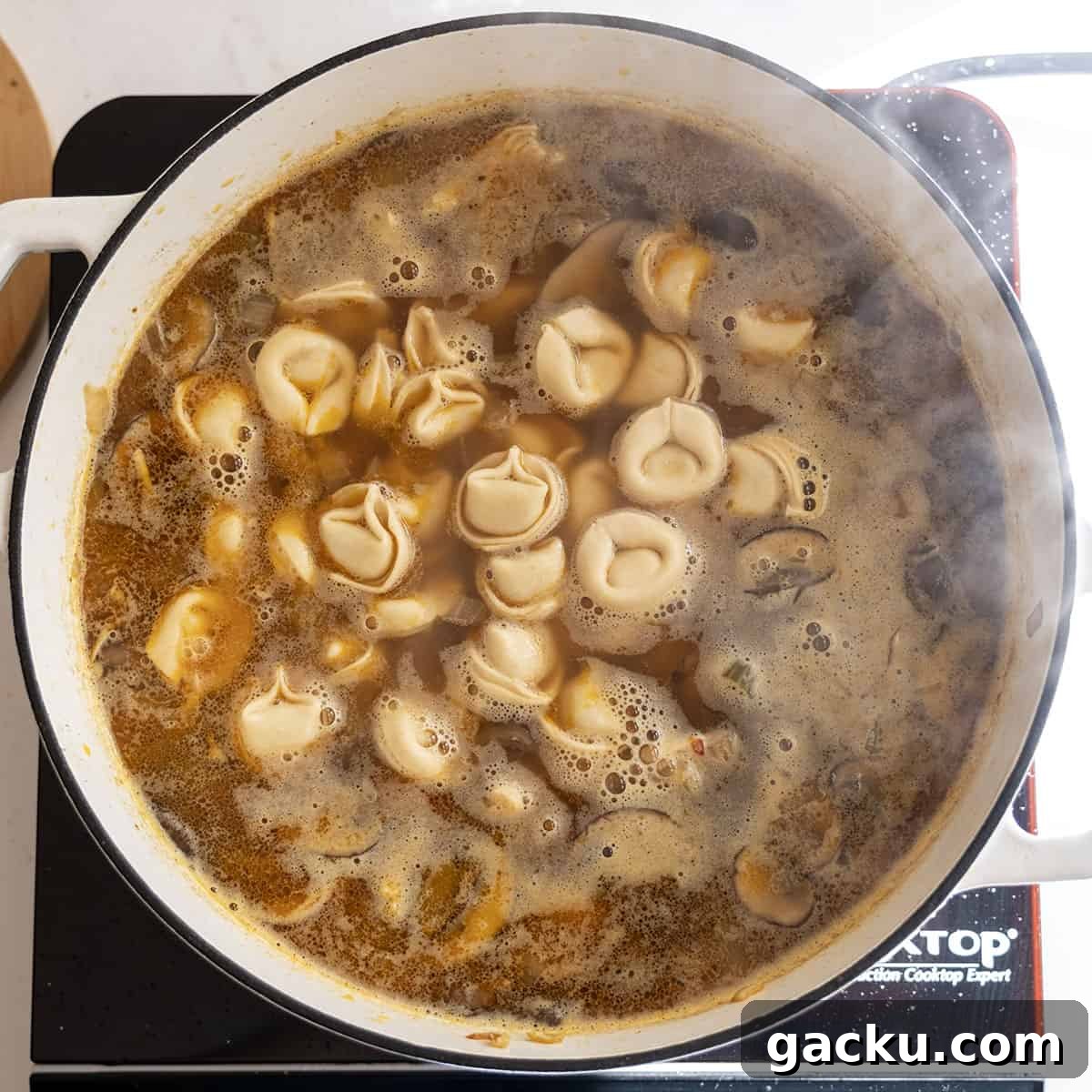 Creamy Chicken Tortellini Soup Recipe for Cozy Weeknights 10 Soup simmering in the pot with tortellini floating on top.