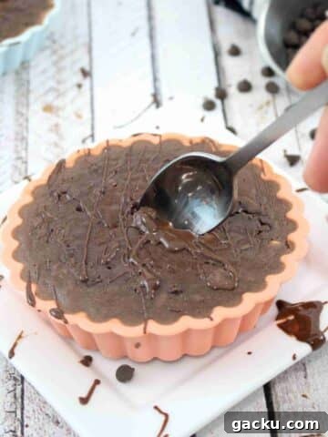 Chocolate baked protein oats in a silicone mold with a spoon in it.