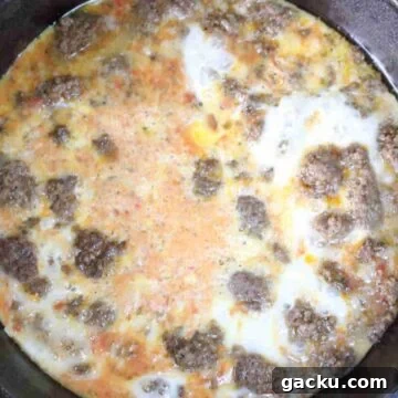 Cooked beef and scrambled eggs in a black skillet.