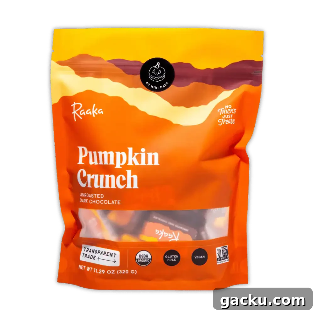 A large orange pouch of Raaka Pumpkin Crunch Unroasted Dark Chocolate is shown against a gray background.