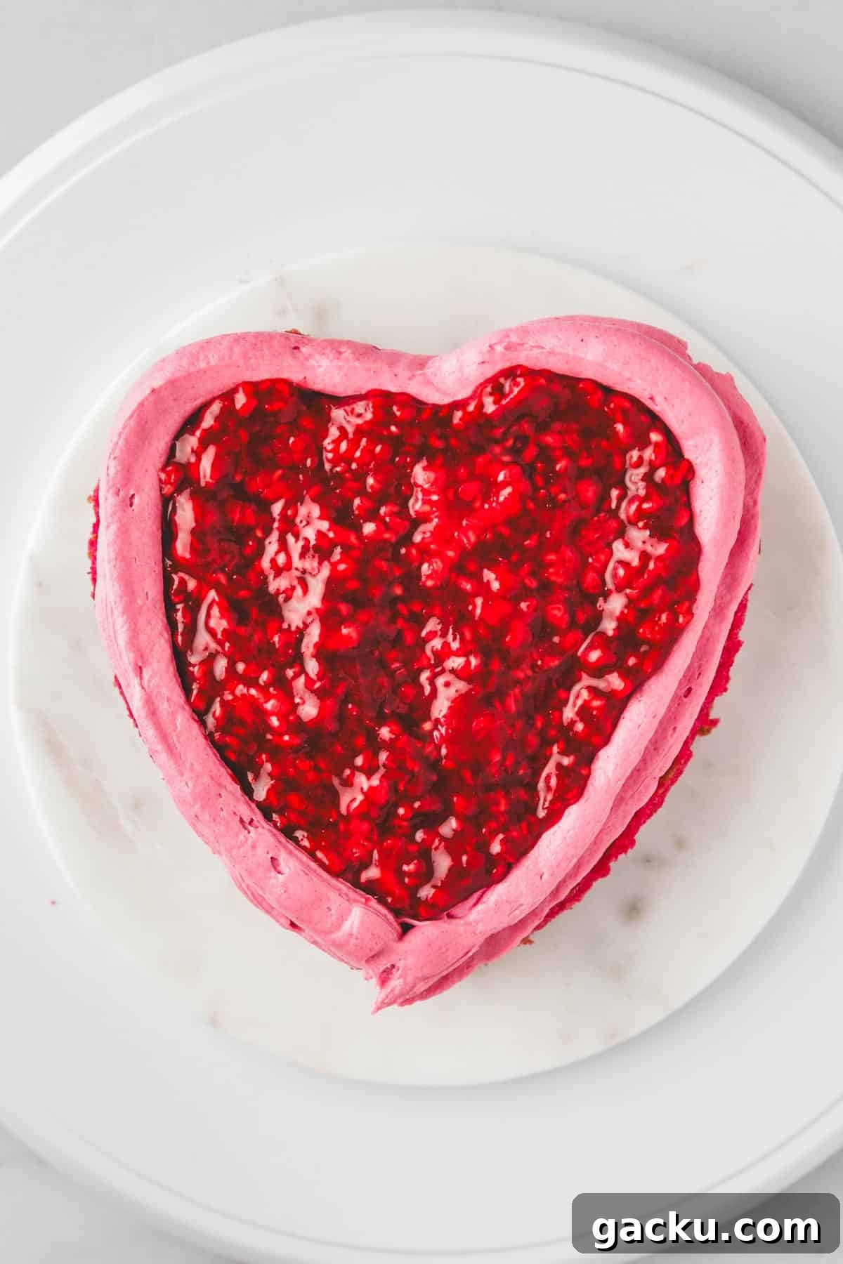 cake board with pink cake layer with raspberry filling