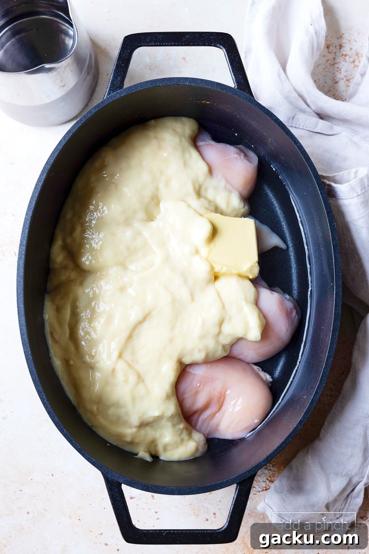 Chicken, butter, cream of chicken soup, and water added to slow cooker insert.