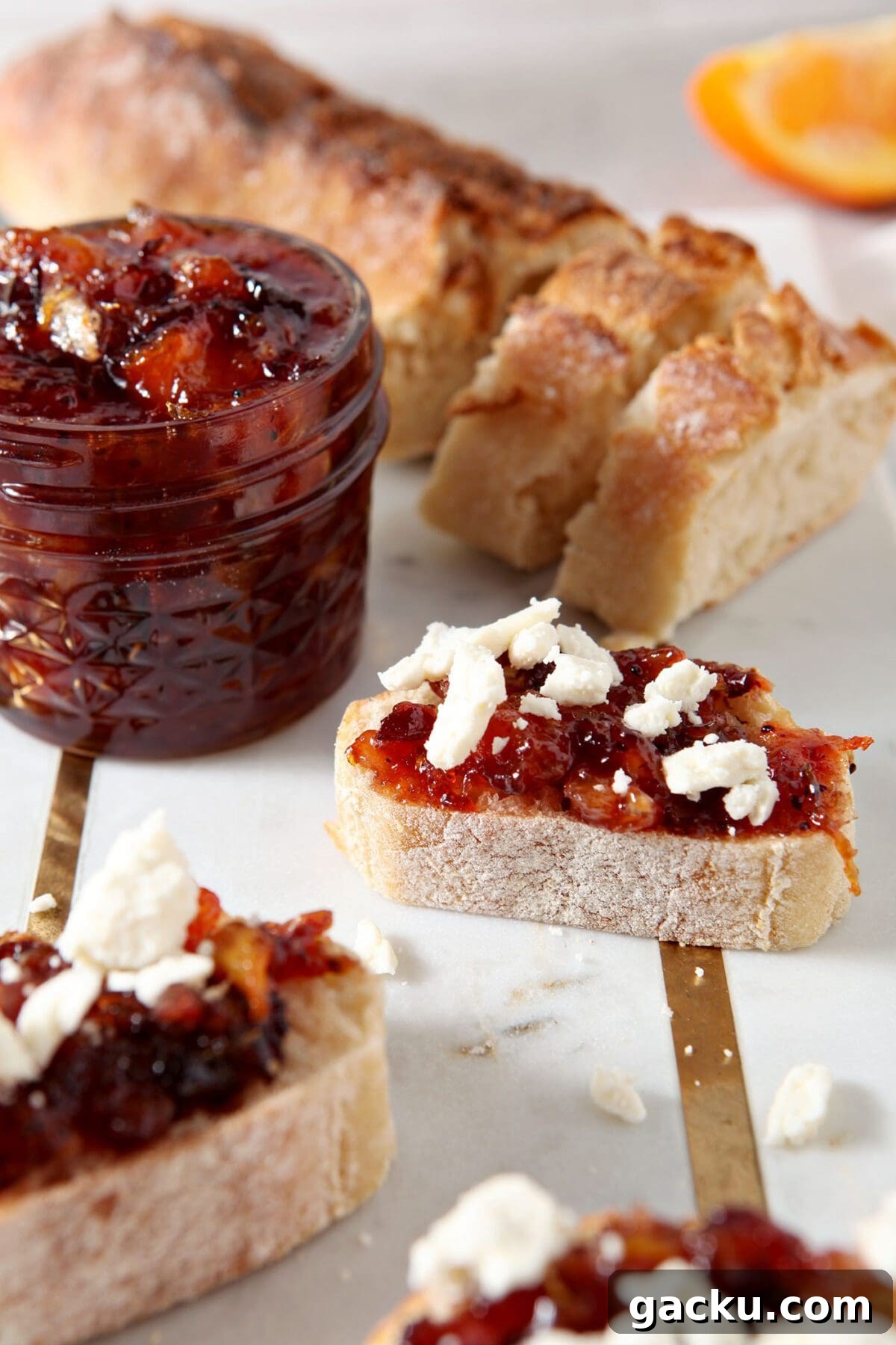 Close up of bruschetta with cranberry compote on top of it and feta crumbles