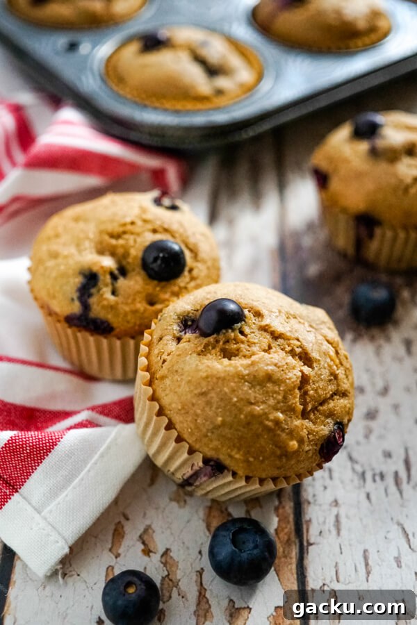 Moist Homemade Blackberry Bread Recipe for Summer Baking 8 Two blueberry bran muffins on a red and white striped towel.