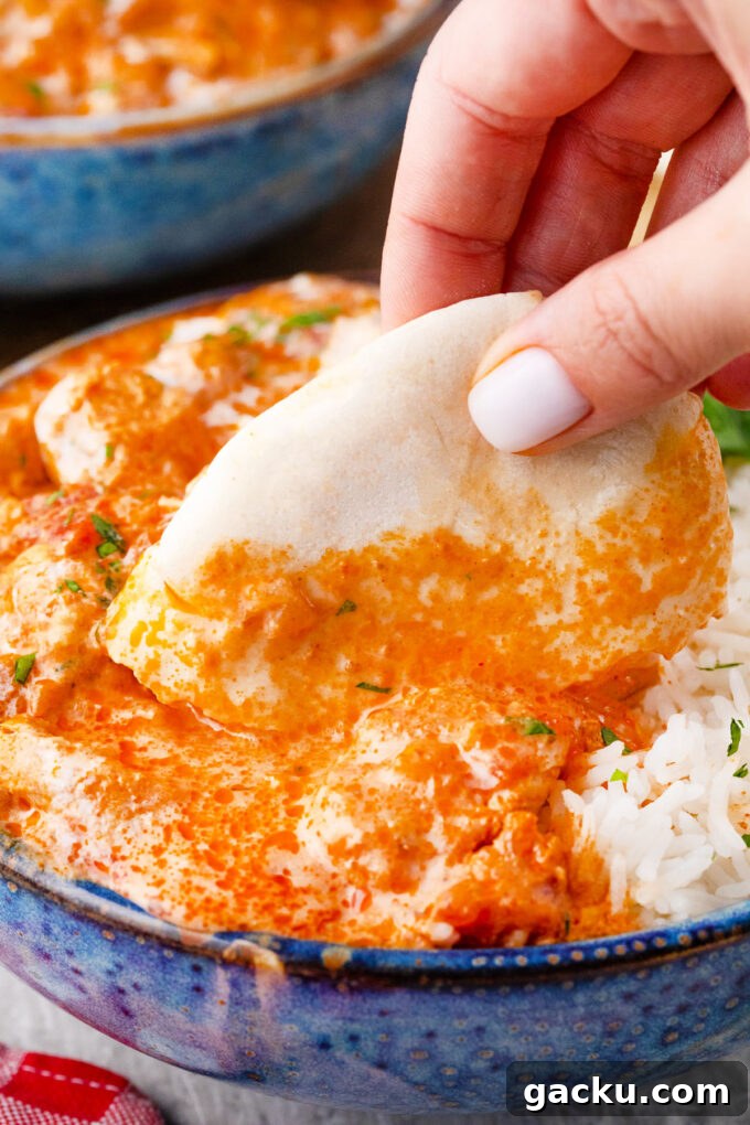 Instant Pot Chicken Tikka Masala with Fragrant Basmati Rice 15 Dipping naan in Instant Pot chicken tikka masala.