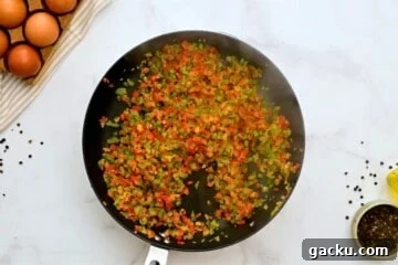 Peppers and onions in large skillet after being sauteed for slow cooker breakfast casserole.