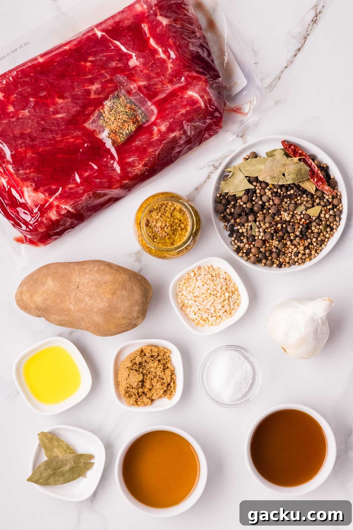 Raw corned beef in packaging, spices, a potato, garlic, mustard, oil, brown sugar, salt, and liquids arranged on a white marble surface.
