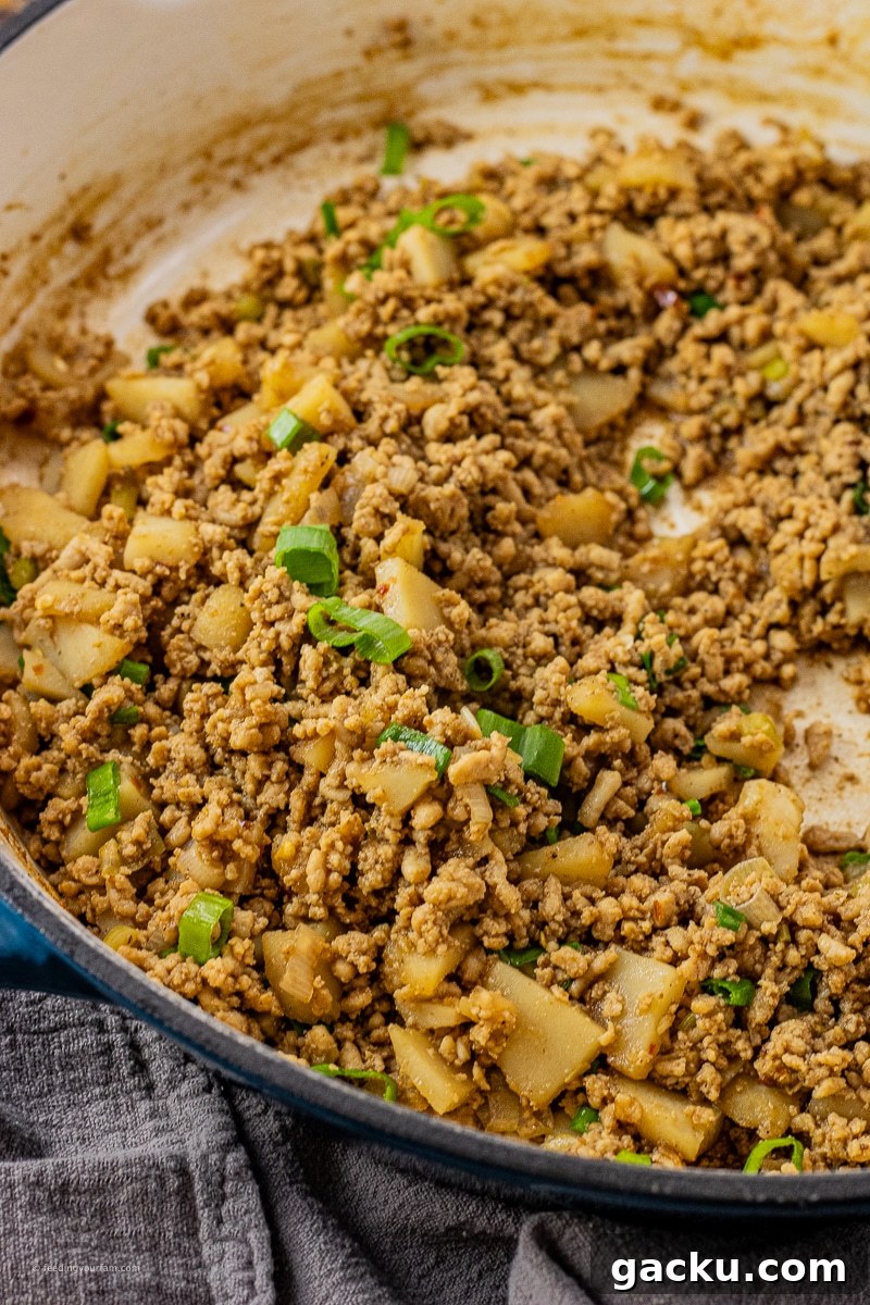 ground chicken with water chestnuts and green onions in a big skillet
