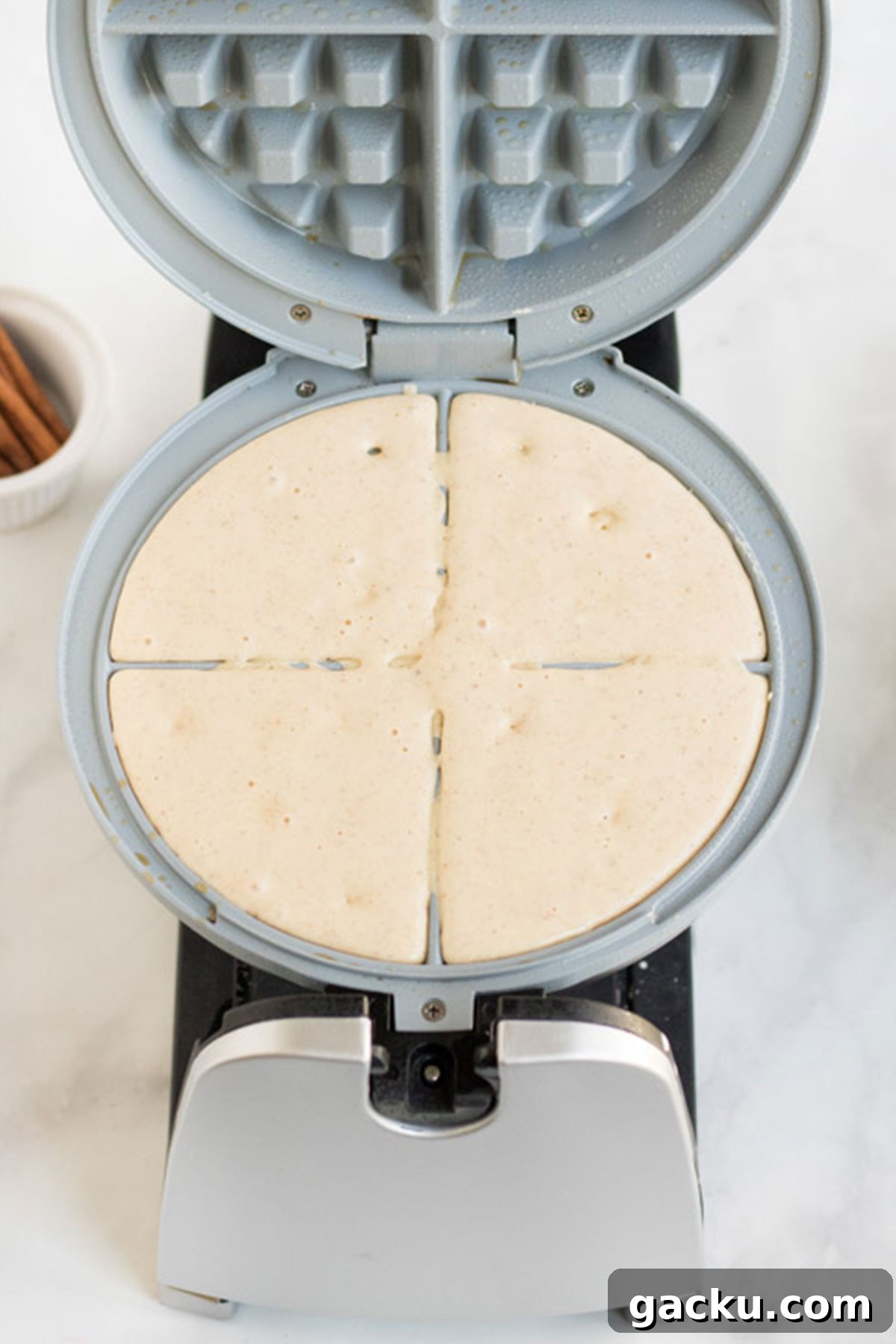 Eggnog Waffle Batter on a waffle iron. 