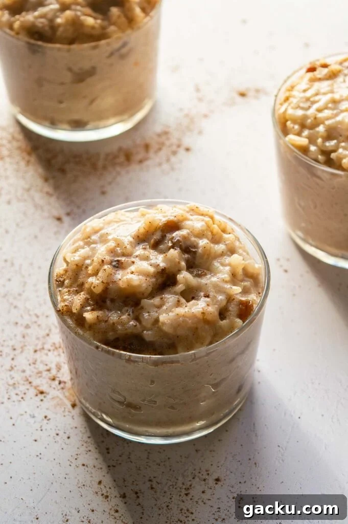 Three jars of creamy rice topped with cinnamon.