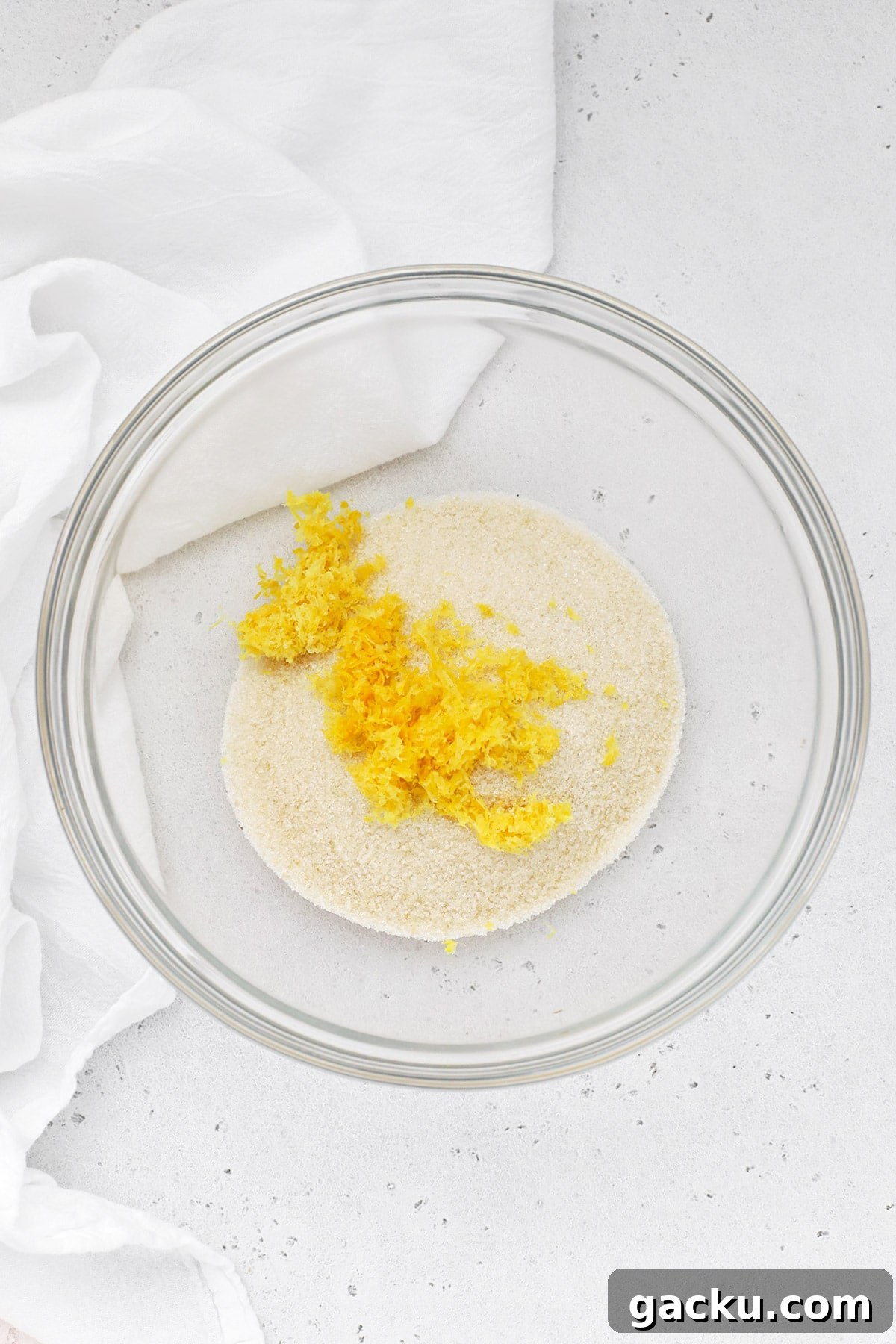 Lemon zest on top of sugar in a glass bowl