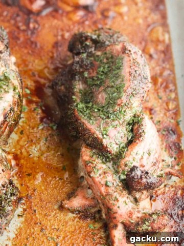 Braided pork on a baking sheet marinated with spices and oil.