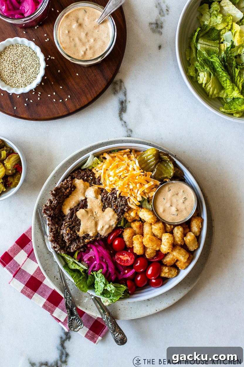 Overhead photo of a burger bowl filled with veggies, cheese and tater tots