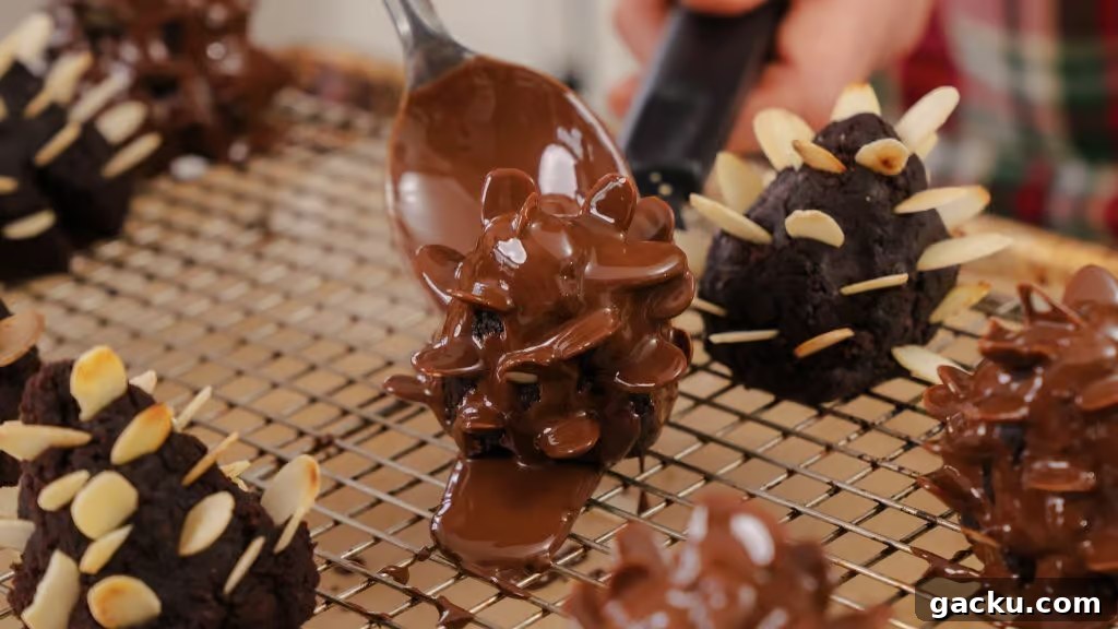 Chocolate Almond Brownie Pinecones — Decadent Dessert Recipe 2 A close up shot of Chocolate Brownie Almond Pinecones being covered in melted chocolate.