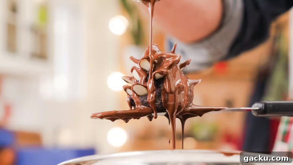 Chocolate Almond Brownie Pinecones — Decadent Dessert Recipe 3 A close up shot of Chocolate Brownie Almond Pinecones being covered in melted chocolate.